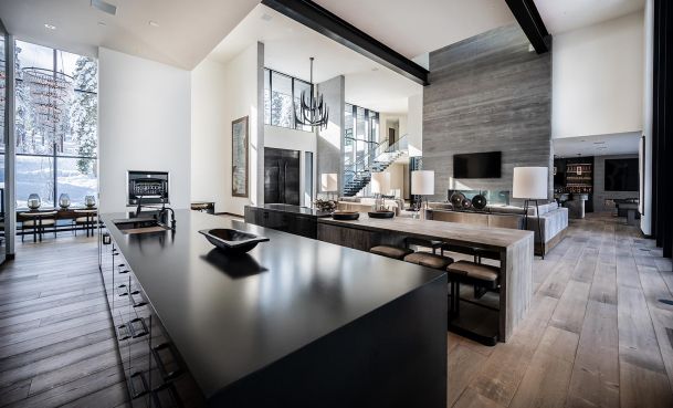 Modern house viewed from the kitchen black counter with white walls and an accent grey wall with a TV