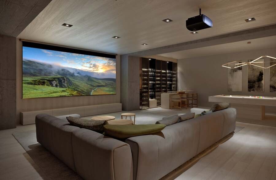 A luxury home theater with a Sony projector displaying a landscape.