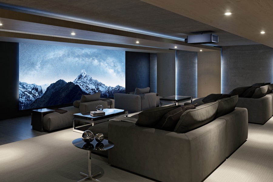 A home theater with chaise lounges, a Sony projector, and a large screen depicting snow-capped mountains.