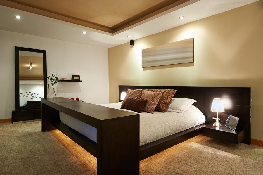 A bedroom illuminated by various lighting fixtures.