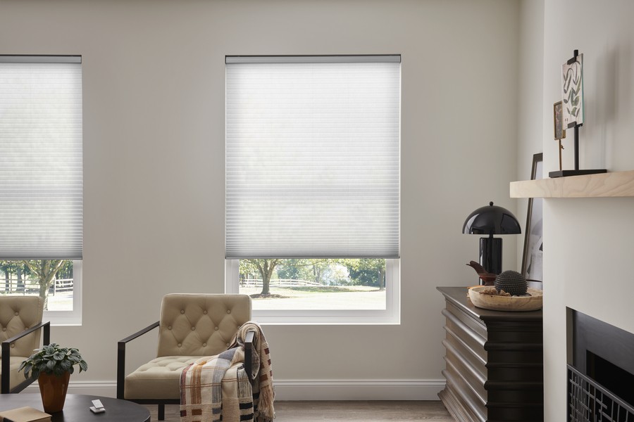 Living space with honeycomb motorized shades on a window.