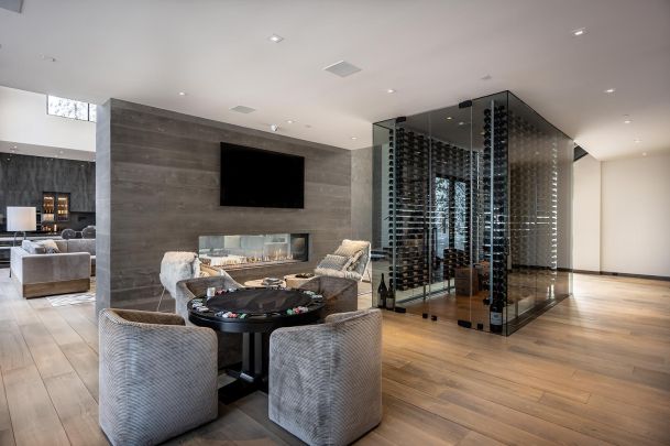 Wine cellar and poker table with an accent grey stone wall with a TV