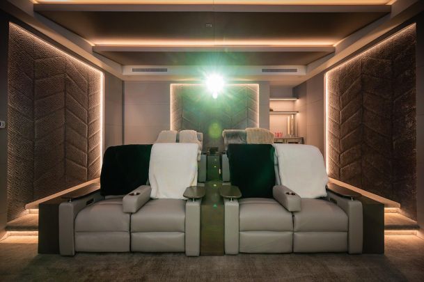 Home theater with LED lighting in neutral colors with beige home theater seating